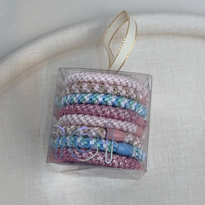 Close-up of durable woven high-elastic hair ties in a clear gift box with ribbon
