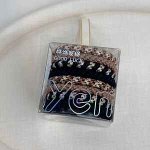 Detail of high-elastic braided hair ties in leopard print and black in a clear gift box