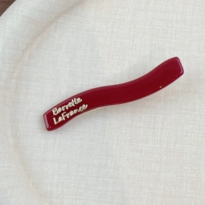 Barrette à cheveux ondulée rouge foncé avec lettrage doré Barrette LaFrance sur beige