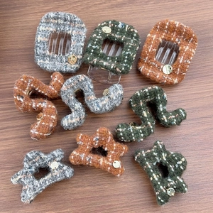 French style tweed hair claw clips in star and wave shapes with gold charms on wood