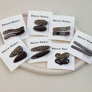 Retro leopard print and solid brown hair clip sets on a display card for styling