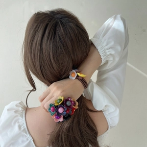 Nahaufnahme von bunten Blumen-Haargummis in einem Pferdeschwanz für einen süßen Look