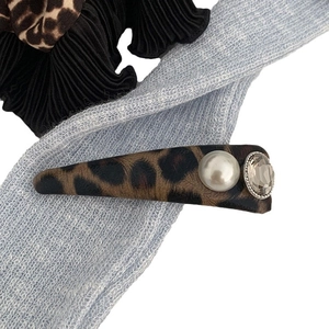 Leopard print hair clip set with faux pearl and crystal on blue textured background