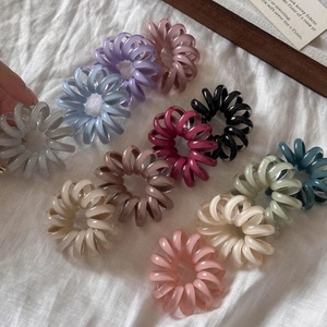 Detail view of multicolored spiral elastic hair ties in a variety of vibrant Morandi tones