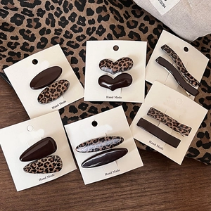 Detail view of handmade leopard print and coffee brown resin hair clips in various shapes