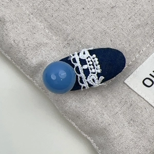 Nahaufnahme der blauen Perlen-Denim-Spitzen-Haarklammer mit Textur und Handwerk