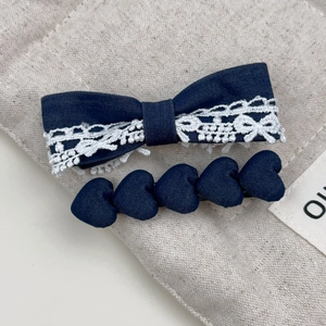 Detail von blauer Denim-Schleife mit Spitze und herzförmiger Denim-Haarspange im Set