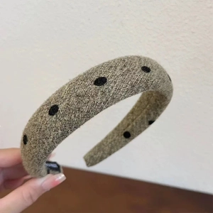 Detail shot of grey velvet sponge headband with black polka dots and textured fabric finish