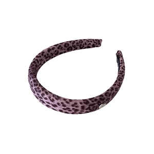 Pink leopard print padded headband with elegant metallic logo charm and soft fabric