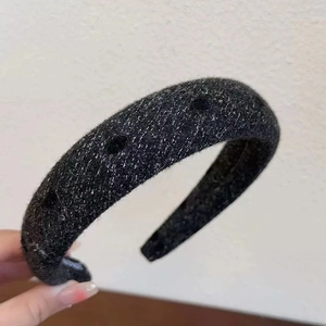 Detailed texture of black velvet headband with elegant silver metallic threading