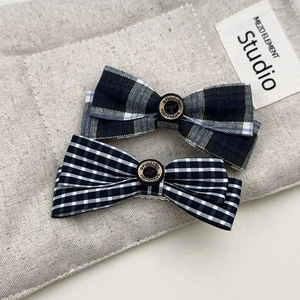 Barrettes à nœud à carreaux bleu et noir avec boutons vintage sur lin beige naturel