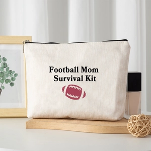 Linen canvas cosmetic bag with Football Mom print on a wooden tray with decorations