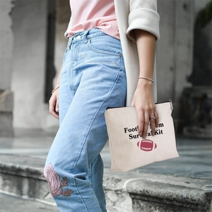 Linen pouch with Football Mom Survival Kit text and rugby icon held by a model