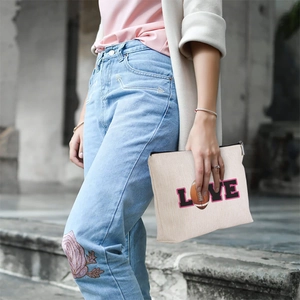 Detail of linen-style makeup bag with LOVE rugby print and metal zipper closure