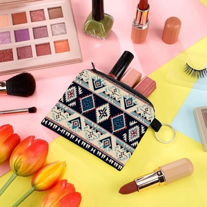 Aztec pattern coin purse with metal keychain shown alongside beauty products