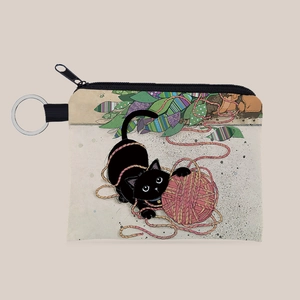 Close-up of canvas coin purse featuring black cat playing with pink yarn and silver keyring