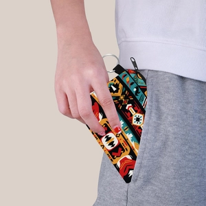 Aztec print coin purse with keychain being placed into a pocket by a hand