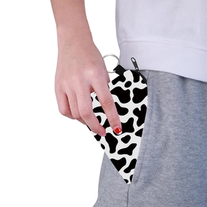 Portable triangle coin purse with black and white cow print and metal keychain hook