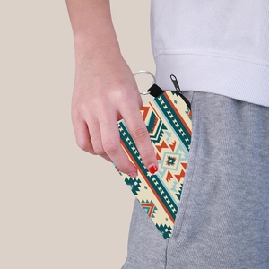 Aztec print coin purse with keychain being placed in a pocket for women