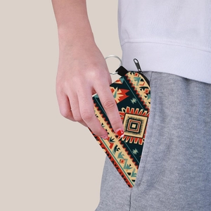 Aztec print mini coin purse with keychain being placed into a pant pocket