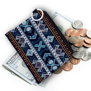 Close-up of portable Aztec print coin purse with silver keychain on currency background