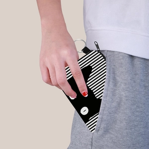 Portable cat striped coin purse with metal keyring being tucked into a pocket