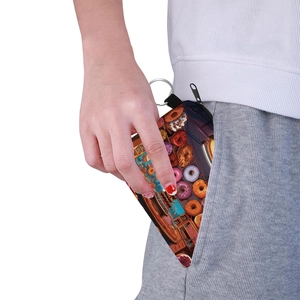Portable doughnut print coin purse with keychain shown fitting into a trouser pocket