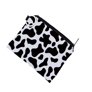 Detail of a cow print coin purse with a silver metal ring and zipper closure for women