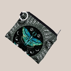 Detailed view of butterfly print coin purse with silver keychain and moon phase pattern