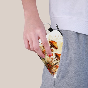 Colorful mushroom print triangle coin purse with keychain being tucked into a pocket