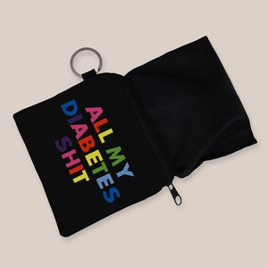 Dettaglio custodia nera con stampa 'ALL MY DIABETES SHIT' e portachiavi in metallo