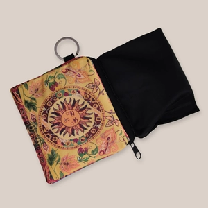 Detail showing a sunflower print pouch with a foldable black nylon shopping bag inside