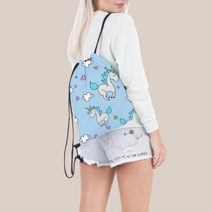 Blue drawstring backpack with unicorn print shown on model for travel and storage