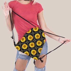 Detail shot of the yellow sunflower and white polka dot pattern on black canvas drawstring bag
