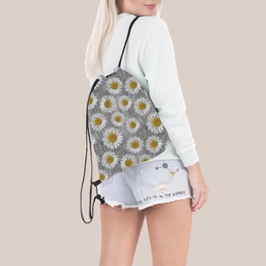 Detail of sunflower print drawstring backpack worn on shoulders with grey floral canvas