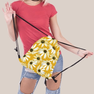 Detail view of sunflower print drawstring backpack worn by a model in casual attire