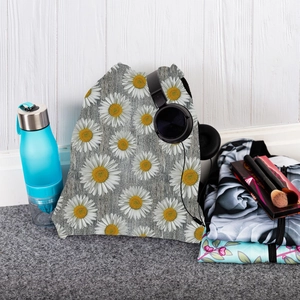 Sunflower print drawstring backpack with daily essentials on a neutral background