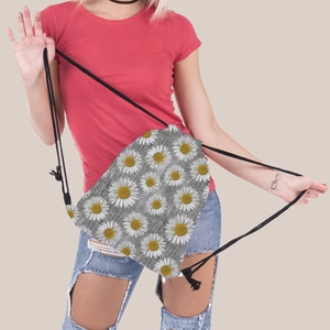 Close-up of grey drawstring bag with sunflower pattern carried by a model outdoors