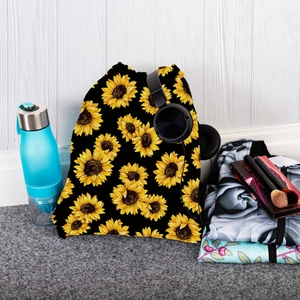 Sunflower drawstring backpack with travel essentials on a striped wood background