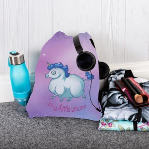 Detail of unicorn drawstring bag with travel gear against a white wooden background