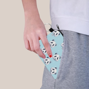 Close-up of portable panda coin purse being placed into a pocket with a metal keychain