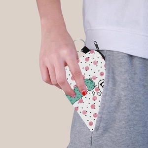 Mini canvas coin purse with green alpaca print being placed into a pocket