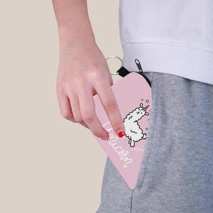 Petit porte-monnaie rose licorne inséré dans la poche d'un pantalon de sport