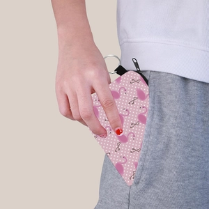 Petit porte-monnaie avec imprimé flamant rose glissé dans une poche avec porte-clés