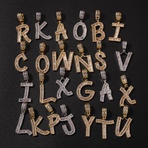 Detailed macro view of iced out cubic zirconia initial pendants on black background