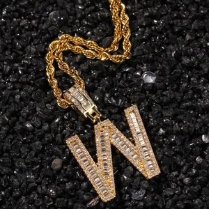 Detailed close-up of golden letter W pendant with sparkling baguette and round zircon stones