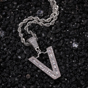 Macro detail of silver V-shaped letter pendant with baguette-cut and round-cut cubic zirconia