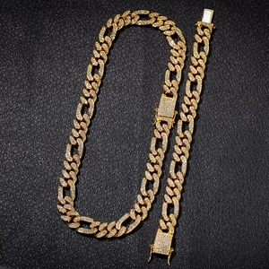 Detail of gold iced out Cuban link chain necklace and bracelet set with rhinestones