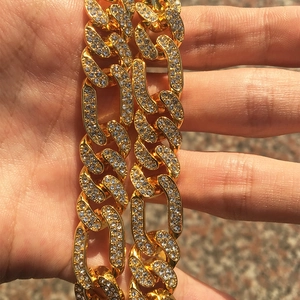 Close-up of hip hop gold Cuban link chain necklace with detailed white rhinestone setting