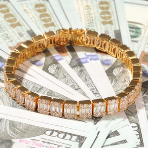 Macro shot of gold hip hop bracelet with baguette zircons and secure double clasp